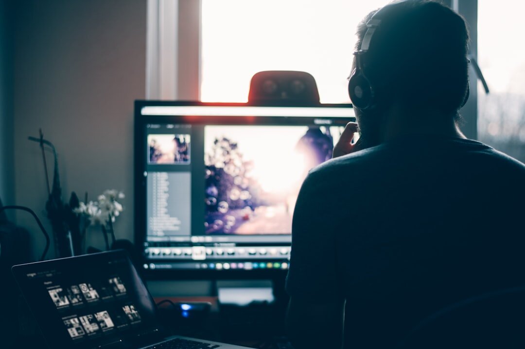 Video editor working at a multi-monitor editing desk